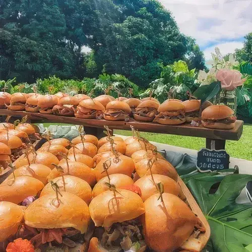 Trays of Umekes sliders set out on a stand for an outdoor party