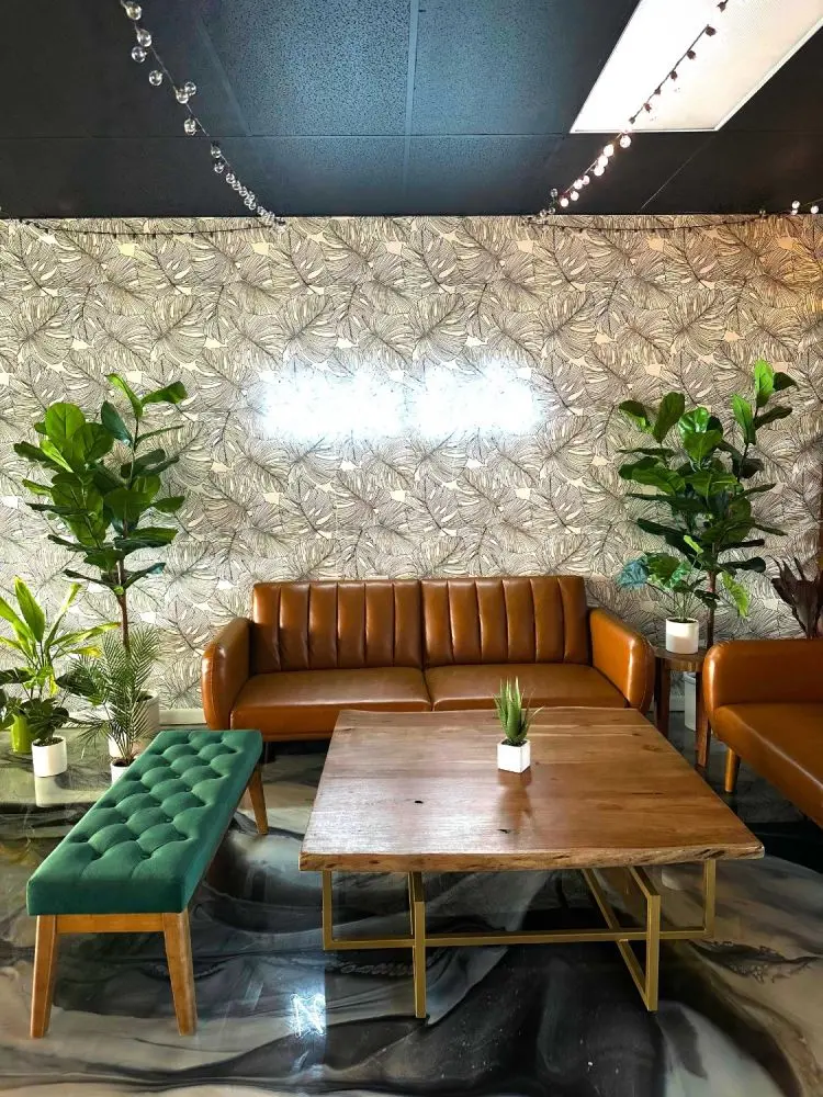 The Umekes event space lounge with leaf wallpaper, string lights and leather sofas