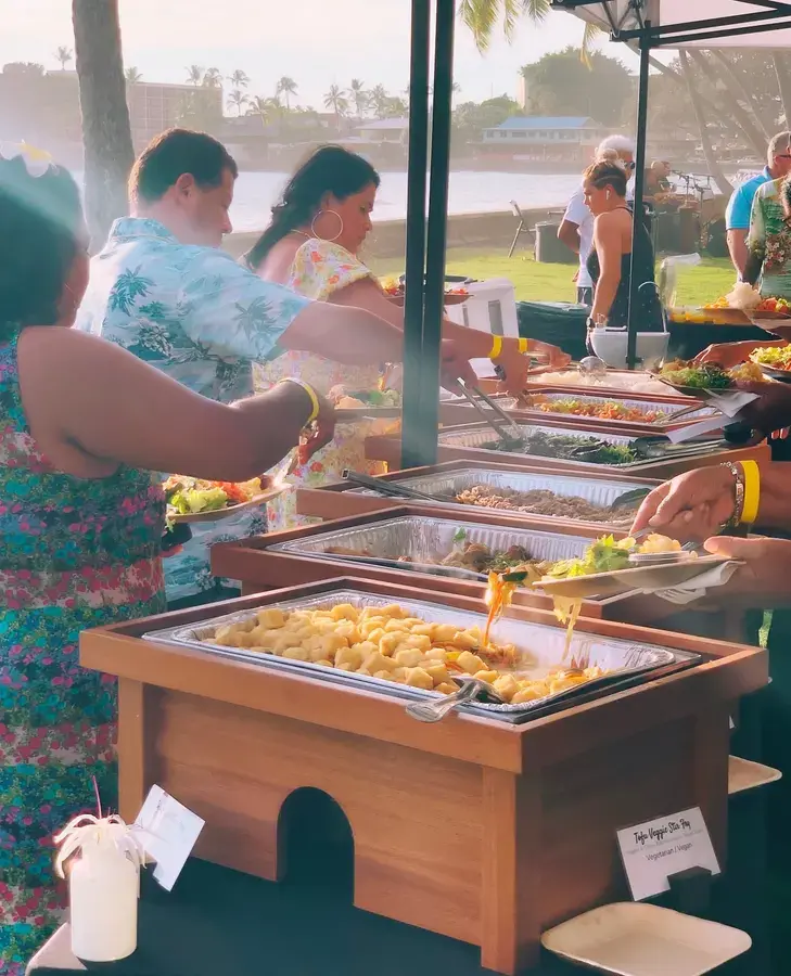 Guests serving themselves from Umekes chafing dishes at an oceanfront lunch