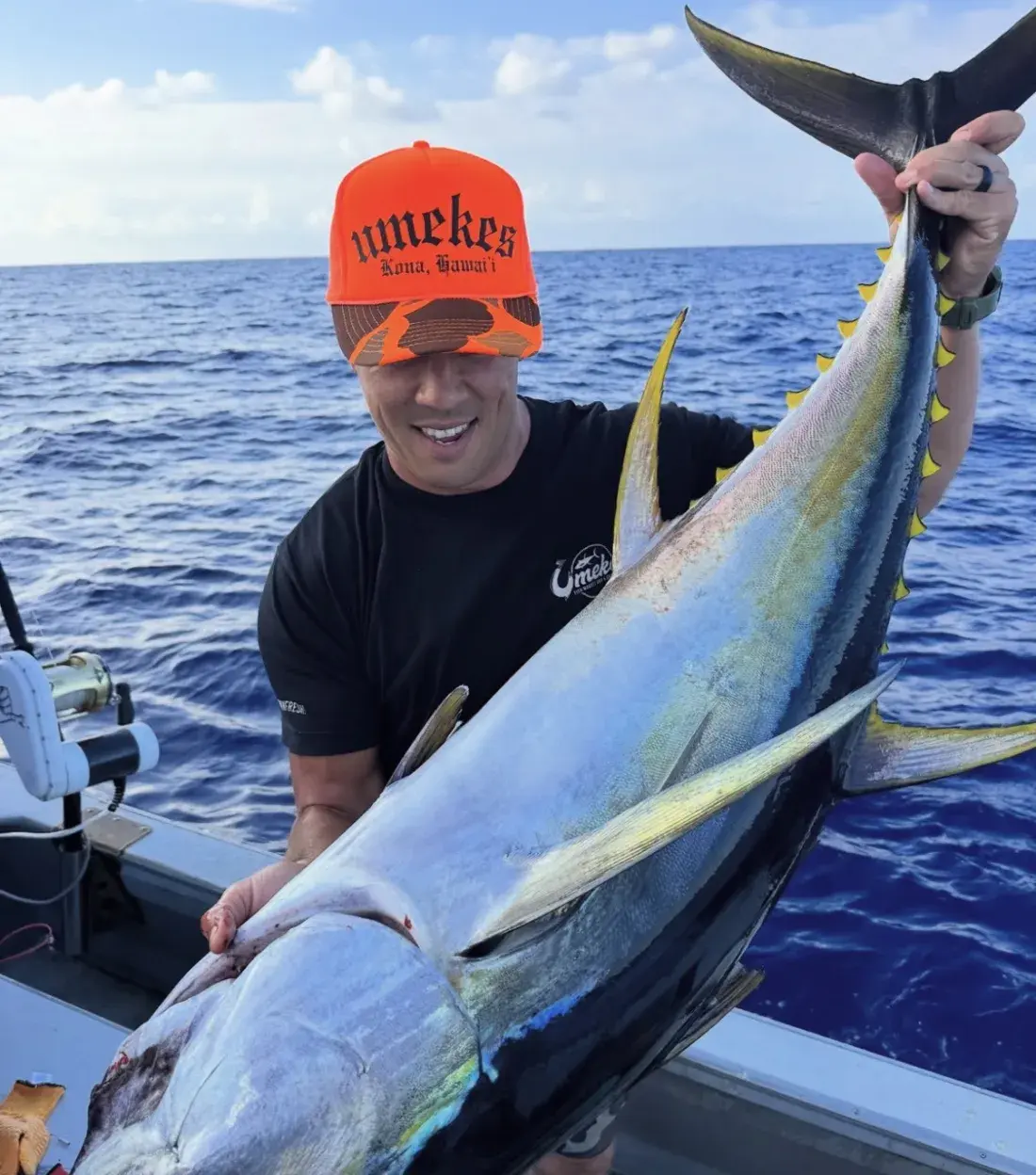 Chef Nakoa Pabre holding a freshly caught yellowfin ahi on the boat