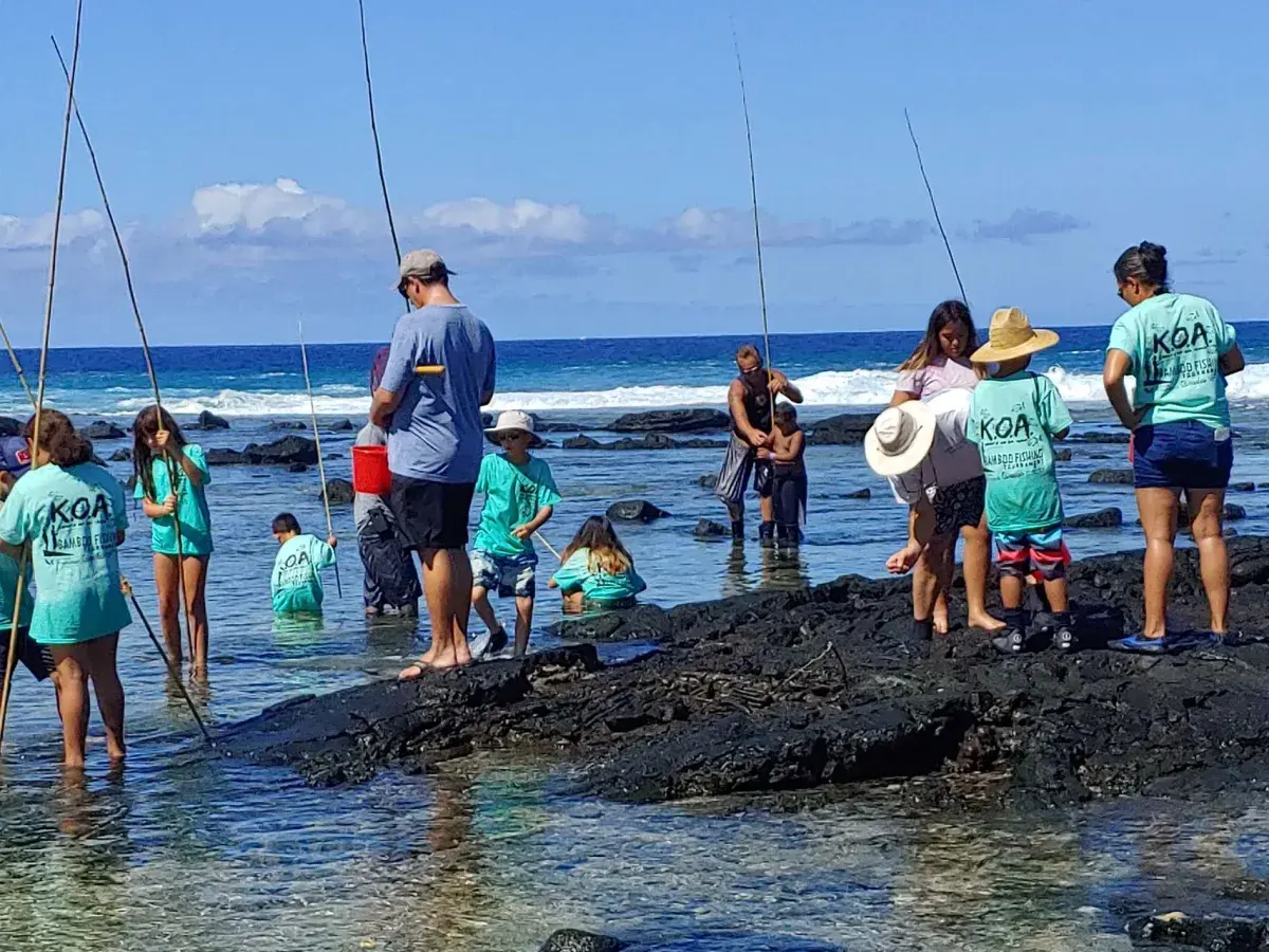 Keiki bamboo-pole fishing off the rocks at a KOA Foundation tournament in Kona