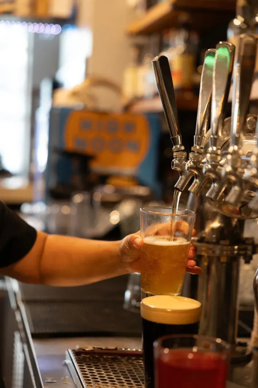 A bartender pulling a draft beer at the Umekes bar in Kona