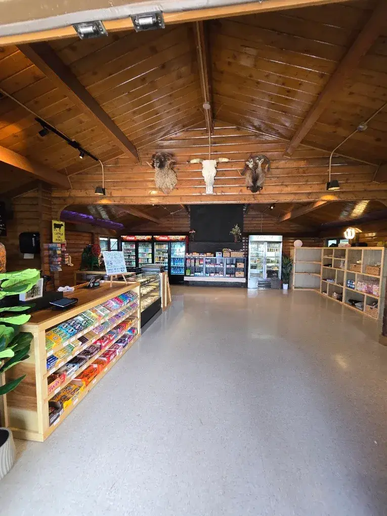 Inside Umekes Saddle Stop, a long wood-paneled room with snack shelves and the counter